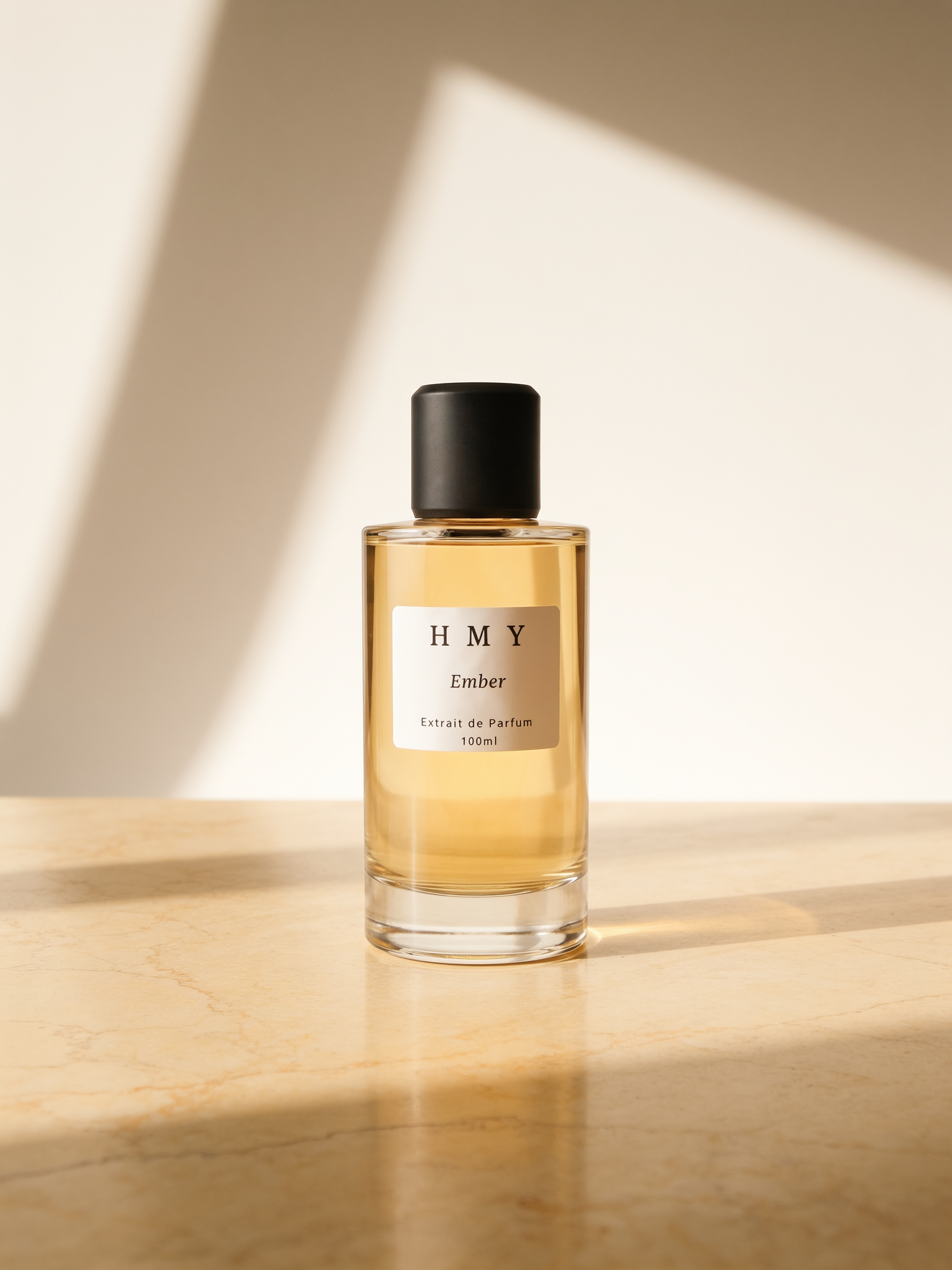 HMY Ember — Extrait de Parfum, 100 ml bottle on warm marble in window light
